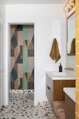 Inspired by the house’s California ranch setting and the natural brush of the surrounding foothills, the designer papered one of the walls in the primary bathroom with geometric-patterned wallcovering by Kelly Wearstler for Kravet.