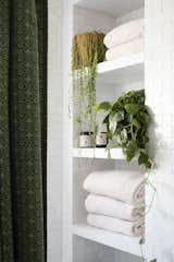 The designer created built-in cubbies that hold towels, plants, and bathing necessities for the kids' bathroom.