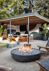 The fire pit area displays a 48-inch concrete fire bowl, woven chairs, and upcycled tree stumps for kid-friendly-seating.