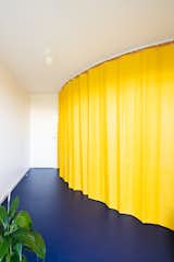 Living Room, Linoleum Floor, and Ceiling Lighting A curved, yellow curtain can section off the kitchen and bathroom from the living area.