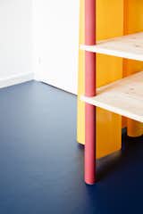 Storage Room and Shelves Storage Type A bright-red pillar contrasts with the yellow curtain and the blue linoleum flooring to create a composition of primary colors.