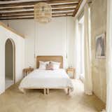The bedroom displays more existing wood ceiling beams and a storage loft above the bathroom.