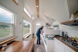 The living area's Gemini sofa by Resource Furniture converts easily to a bunk bed: "It takes just one hand to open and transform the sofa,  Photo 5 of 15 in A Retired Couple Set Out for Adventure in an Off-Grid Tiny House