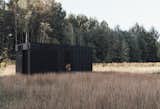 Aylott &amp; Van Tromp's Nokken modular cabin, a hotel-suite-like accommodation that can be adapted to suit almost any remote location, is clad with black-stained European larch and perforated metal paneling.