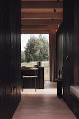 Hallway and Light Hardwood Floor Pale-toned European larch flooring and ceilings are juxtaposed with the dark-stained walls of the cabin, lending stark contrast and drama for the interior.  Photo 3 of 11 in These Tiny Prefab Cabins Are Designed to Feel Like Luxe Hotel Rooms from A Svelte $79K Prefab Cabin Promises to Work as Well in Your Backyard as It Does in the Woods