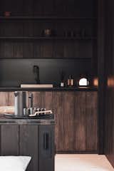 The kitchen cabinetry is crafted from European larch that’s finished with a deep brown tone that mimics the color of tree trunks.