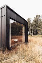 The large picture window in the bedroom area blurs the distinction between the interior and the natural landscape.