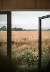 Large glass doors frame views of the pastoral setting.