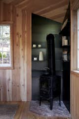 A wood-burning stove in the corner of the tree house offers warmth for the interior.