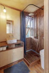The shower’s thermo-treated pine walls display a subtle pattern that adds interest in the bathroom.