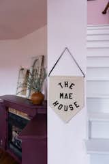 A pennant sign by Black-owned company Rayo and Honey with the property’s moniker hangs on a wall near the entry.