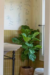 Mustard-yellow Fireclay tile complements a hand-painted wall mural depicting various flora in the primary bathroom.