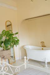 The clawfoot tub in the primary bathroom is from Kohler; the plant is from Juanita’s Plants.