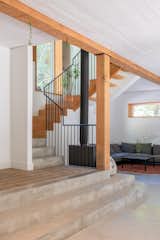 Tyler fabricated the metal stair rail, which contrasts with the brick flooring in the entry, the wood stair treads, and the concrete flooring of the living area.