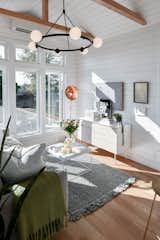 Expansive windows flood the living area, outfitted with hickory flooring and ceiling beams, with plenty of natural light.  Photo 3 of 13 in Budget Breakdown: A $237K Tiny Home on Wheels Brings Kids, Parents, and Their Parents Together