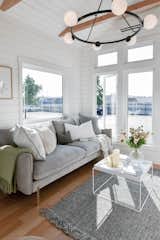 The farmhouse-style light fixture that suspends from the living room ceiling is from West Elm.  Photo 5 of 13 in Budget Breakdown: A $237K Tiny Home on Wheels Brings Kids, Parents, and Their Parents Together
