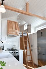 A ladder accesses a storage loft above the bathroom.  Photo 8 of 13 in Budget Breakdown: A $237K Tiny Home on Wheels Brings Kids, Parents, and Their Parents Together