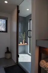 The spa-like bathroom's shower walls and flooring feature more concrete with glass beads that lends a serene, elemental quality to the space.