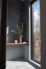 A floor-to-ceiling window in the shower provides the feeling of showering outdoors.