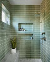 Olive-green Fireclay tile creates a spa-like experience in the bathroom and fluctuates in tone throughout the day.