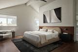 The new primary bedroom displays walnut flooring and a built-in headboard.