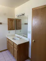 Blond wood cabinetry and dated tile flooring overtook one of the bathrooms.
