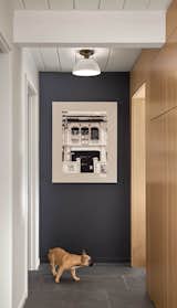 The architects lined the hallway adjacent to the kitchen with oak storage cabinets.