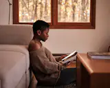 Julie reads and relaxes on the floor in the living area.