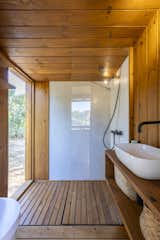 The large bathroom features an expansive shower with a large opening that provides the feeling of showering outdoors.