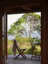 The covered deck offers a place to sit and enjoy a drink and expansive views of the landscape.