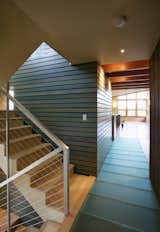The horizontal blue-stained siding wraps to the interior core at the entry - translucent glass floor panels bring daylight to the lower level.