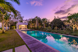 Outdoor, Grass, Large Pools, Tubs, Shower, Wood Patio, Porch, Deck, Lap Pools, Tubs, Shower, and Back Yard  Photo 5 of 5 in A Glowing Home in Florida Asks $4M by Sotheby’s International Realty