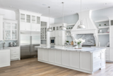 Kitchen, Medium Hardwood Floor, Marble Backsplashe, Refrigerator, Pendant Lighting, Undermount Sink, Ceramic Tile Backsplashe, Recessed Lighting, White Cabinet, Marble Counter, and Wall Oven  Photo 3 of 5 in An Expansive Home in Kentucky Asks $2.695M by Sotheby’s International Realty