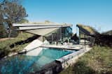 Exterior and House Building Type The concrete, steel, and glass house is divided into two distinct public and private halves.  Photos from 25 Green Roofs That Bring Spectacular Homes to New Levels