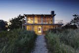 Perched atop the crest of the dune between the ocean and bay, this home in the Hamptons utilizes elegant materials which were chosen for their simplicity, sustainability, low maintenance and ability to coexist with the sea, sand and vegetation of the site. The use of glass also provides the residents with stunning views of their surroundings.