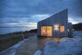 Designed by TYIN tegnestue Architects and built by the owners themselves, this cottage celebrates traditional back-to-nature elements in traditional Norwegian culture. Situated amidst marshland, sea-adjacent rock and scattered pine-and juniper-vegetation, careful consideration was made to protect the sensitive surrounding terrain. Only 328 feet from the sea, some marsh had to be cleared in preparing for the construction, exposing bedrock and integrating the cottage within the landscape.