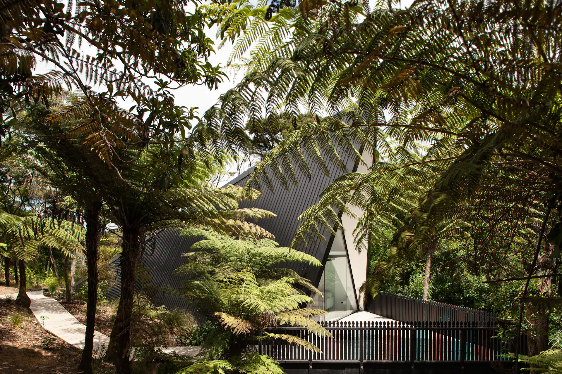 On Waiheke Island near Auckland, New Zealand, the Tent House sits among wetlands on a patch of undeveloped land. It captures the back-to-basics simplicity of camping, thanks to architect Chris Tate. Though he originally created the cabin to be a personal retreat/studio, Tate ended up experimenting with the design in order to challenge conventional expectations of what makes an ideal weekend escape. Now available for short-term rental, the one-bedroom, one-bathroom, 753-square-foot home includes a sleeping area on the mezzanine, a fully functional kitchen, an open-plan living area, and a front deck designed to "fan out."
