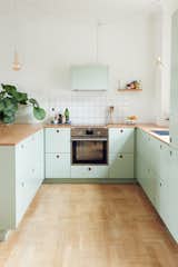 Kitchen, Wood, Light Hardwood, Pendant, Wall Oven, Range Hood, Drop In, Colorful, Cooktops, and Ceramic Tile Danish blogger, Tikkie Elsøe, chose mint green  Kitchen Ceramic Tile Light Hardwood Range Hood Photos from Modern Kitchen Upgrade Ideas From a Danish Design Firm That's Challenging the Kitchen Market