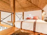 It's an open space with a cathedral ceiling and exposed-cedar beams. There's a queen-sized bed on the main level and another in the loft area.
