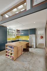 A family's dream of living in a converted warehouse becomes a reality when Zen Architects successfully transforms a leaky warehouse from the 1960s into a bright and airy family home—without compromising on comfort or energy efficiency. Bright yellow subway tiles complement dark teal cabinets and colorful dishware.