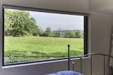 The master bedroom suite features a large picture window with far reaching rural views  Photo 8 of 10 in Historic Gasworks Cottage With a Modern Cor-Ten Steel Addition Hits the Market