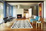 Living Room, Stools, Chair, Sofa, Shelves, Floor Lighting, Medium Hardwood Floor, Rug Floor, Standard Layout Fireplace, and Wood Burning Fireplace  Photo 12 of 31 in Living room by Simon from Experience Cape Cod Modern by Staying at the Midcentury Weidlinger House