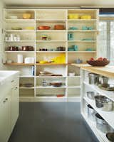 The kitchen's open shelving serves as a colorful display for midcentury-modern cookware.&nbsp;