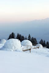 The geodesic domes look like igloos in the snowy Alpine landscape.