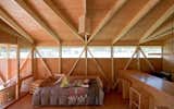 Bedroom, Bed, Chair, Medium Hardwood Floor, and Ceiling Lighting  Photo 6 of 7 in Experience the Magic of Easter Island While Staying in a Modern Eco-Cabana