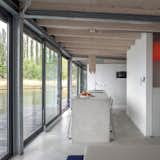 Kitchen, Concrete Floor, Concrete Counter, White Cabinet, Pendant Lighting, Wall Oven, and Drop In Sink  Photo 4 of 9 in Stay in a Modern Houseboat in Berlin With Floor-to-Ceiling Windows