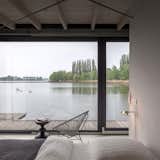 Bedroom, Bed, Chair, Floor Lighting, and Concrete Floor  Photo 8 of 9 in Stay in a Modern Houseboat in Berlin With Floor-to-Ceiling Windows
