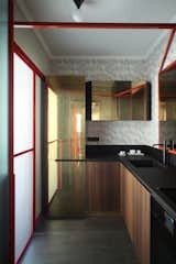 Kitchen, Laminate, Ceiling, Refrigerator, Drop In, Dark Hardwood, and Metal Kitchen: doors in eucalyptus wood and brass, countertop in high-thickness laminate Polaris by Abet, designed by Marcante-Testa, built by Materia Design and Om Project, faucets from Bellosta, lighting from Atelier Areti.  Kitchen Drop In Laminate Dark Hardwood Metal Photos from This Venetian Apartment Is Bursting With Incredible European Furnishings