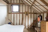 Bedroom, Bed, Dresser, Chair, Wall Lighting, and Carpet Floor Simple farmhouse bedroom style.  Photos from This Spectacular Suffolk Barn Conversion Hits the Market at $1.26M