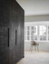 A large kitchen cabinet covered in dark stained oak separates the kitchen from the living room.&nbsp;